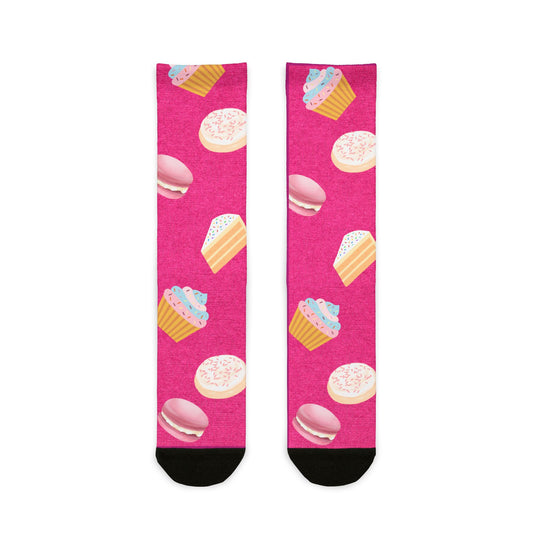 Pink socks with cupcake and macaron patterns on a white background