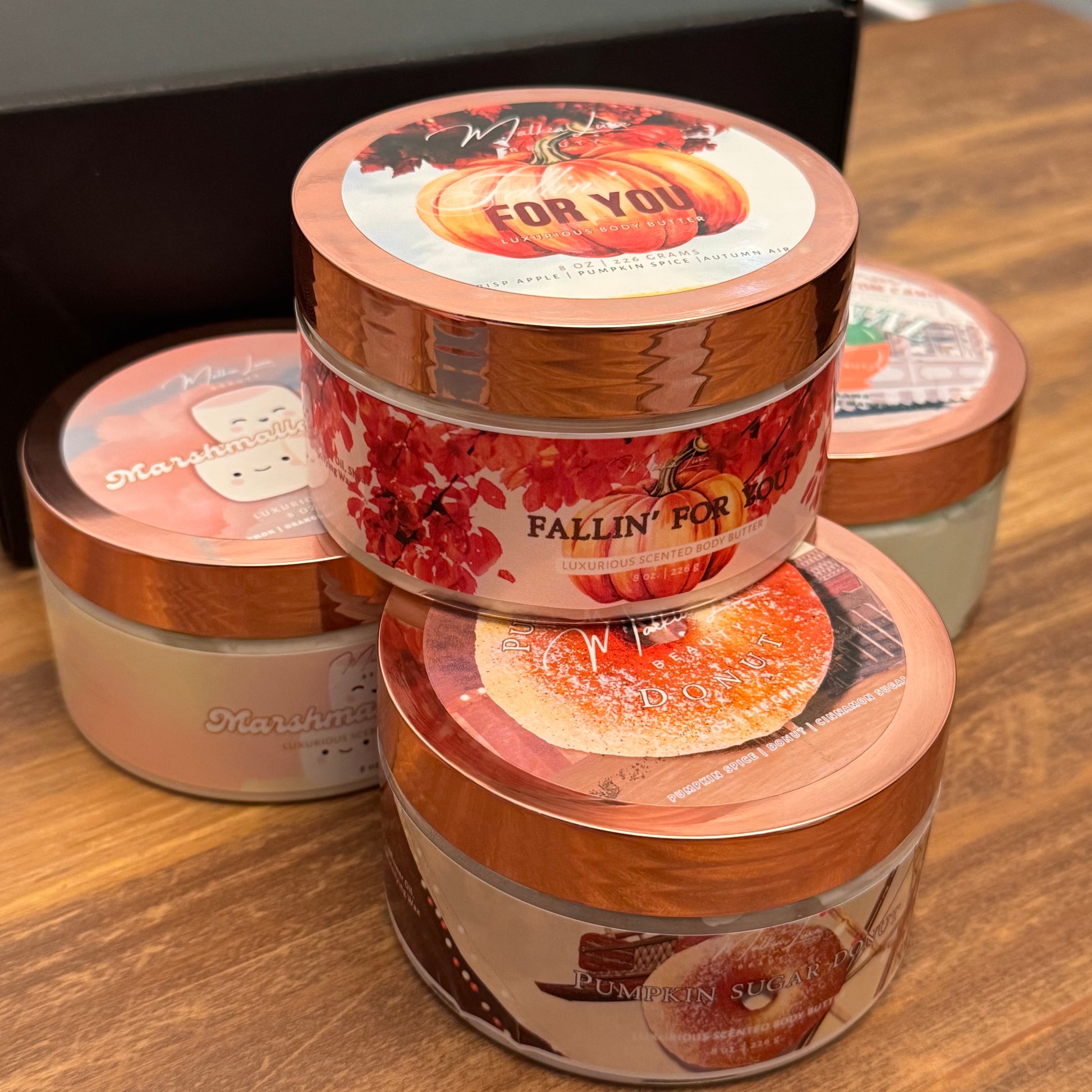Stack of decorative jars with autumn-themed labels on a wooden surface